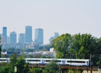 Пьер Пуальевр отметил годовщину Варшавской битвы Skyline of Warsaw with modern buildings and a train passing amidst the greenery.