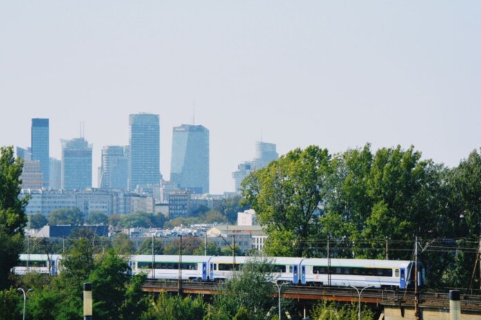Skyline of Warsaw with modern buildings and a train passing amidst the greenery. Skyline of Warsaw with modern buildings and a train passing amidst the greenery.