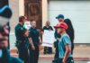 Street protest in Wheeling, WV highlighting immigration issues with signs and police presence.