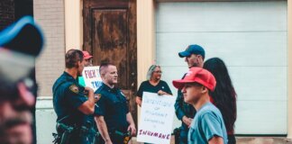 Street protest in Wheeling, WV highlighting immigration issues with signs and police presence.