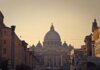 Street view of Saint Peter's Basilica in Vatican City during dusk, capturing the iconic architecture and Roman skyline.