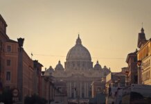 Street view of Saint Peter's Basilica in Vatican City during dusk, capturing the iconic architecture and Roman skyline.