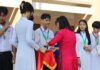 Students receiving medals and certificates during a school award ceremony.