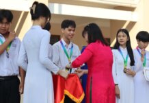 Students receiving medals and certificates during a school award ceremony.