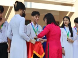 Students receiving medals and certificates during a school award ceremony.