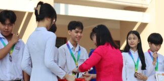 Students receiving medals and certificates during a school award ceremony.