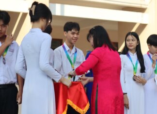 Students receiving medals and certificates during a school award ceremony.
