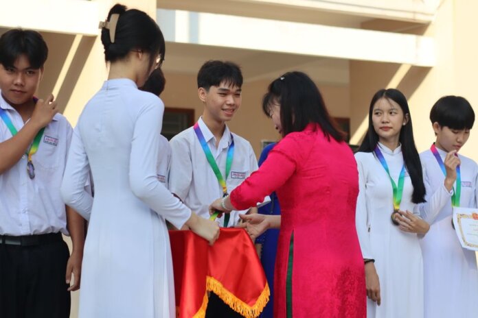 Students receiving medals and certificates during a school award ceremony.