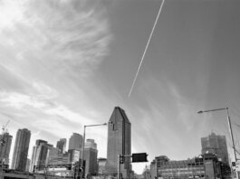 Stunning black and white view of Montreal's skyline featuring tall skyscrapers and dynamic clouds.