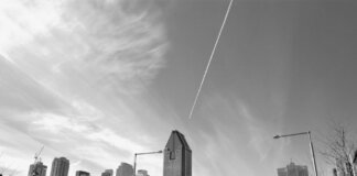 Stunning black and white view of Montreal's skyline featuring tall skyscrapers and dynamic clouds.
