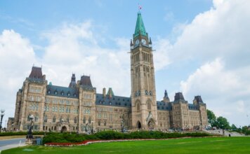 Канада вводит поддержку авиакомпаний из-за волатильности цен на топливо Stunning photo of Canada's Parliament Hill in Ottawa under a clear sky, showcasing Gothic Revival architecture.