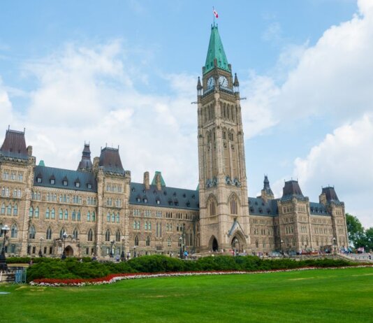 Stunning photo of Canada's Parliament Hill in Ottawa under a clear sky, showcasing Gothic Revival architecture.