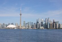 Stunning view of the Toronto skyline featuring the iconic CN Tower by Lake Ontario.