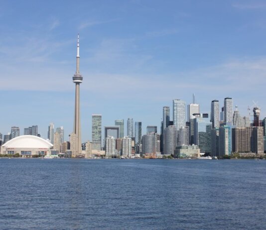 Stunning view of the Toronto skyline featuring the iconic CN Tower by Lake Ontario.