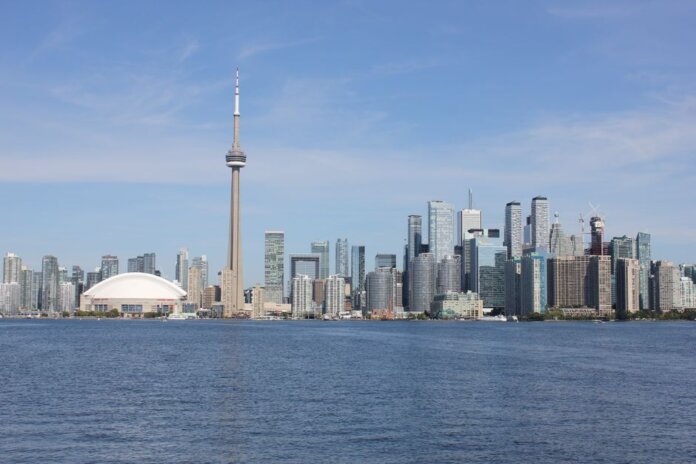 Stunning view of the Toronto skyline featuring the iconic CN Tower by Lake Ontario. Stunning view of the Toronto skyline featuring the iconic CN Tower by Lake Ontario.