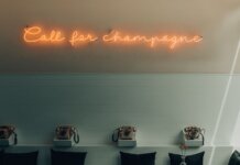 Stylish interior featuring retro telephones and a neon 'Call for Champagne' sign.