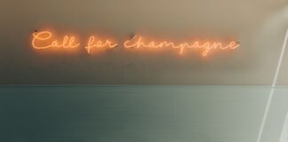 Stylish interior featuring retro telephones and a neon 'Call for Champagne' sign.