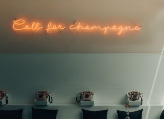 Министр Шампань откроет торги на Торонтской бирже Stylish interior featuring retro telephones and a neon 'Call for Champagne' sign.