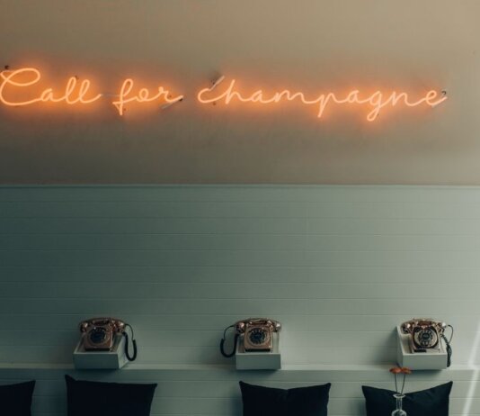 Stylish interior featuring retro telephones and a neon 'Call for Champagne' sign.
