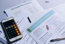 Пьер Пуалиевр призывает отменить налог на бензин до Дня Канады 2027 года Tax preparation setup with documents, smartphone calculator, and checklist.