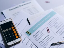 Tax preparation setup with documents, smartphone calculator, and checklist.