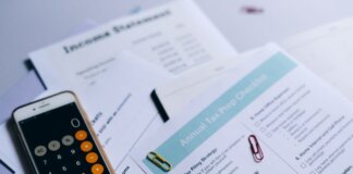 Пьер Пуалиевр призывает отменить налог на бензин до Дня Канады 2027 года Tax preparation setup with documents, smartphone calculator, and checklist.