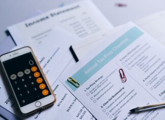 Tax preparation setup with documents, smartphone calculator, and checklist.