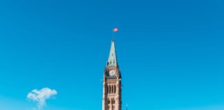 The Peace Tower of Canada's Parliament in bright daylight against a blue sky.