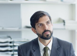 Как руководителям-мужчинам реагировать на сексизм в команде — исследование UBC Thoughtful businessman in suit and tie in modern office environment.