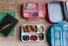Школьное питание в Канаде: новая программа меняет привычный уклад Top view of composed plastic lunchboxes near copybooks under pencils on wooden table