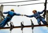 Канада выделяет $7,5 млрд на поддержку бизнеса и работников из-за тарифов США Two electrical workers in blue uniforms collaborating on power lines during daytime.