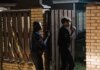 В Уитби арестован мужчина по обвинению в домогательстве к детям Two police officers investigate a crime scene at night, entering a house with caution.