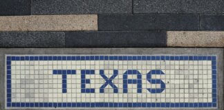 Unique mosaic tile artwork spelling 'Texas' on a sidewalk in Houston, TX.