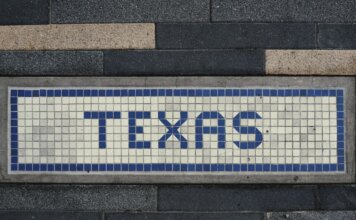 Unique mosaic tile artwork spelling 'Texas' on a sidewalk in Houston, TX.