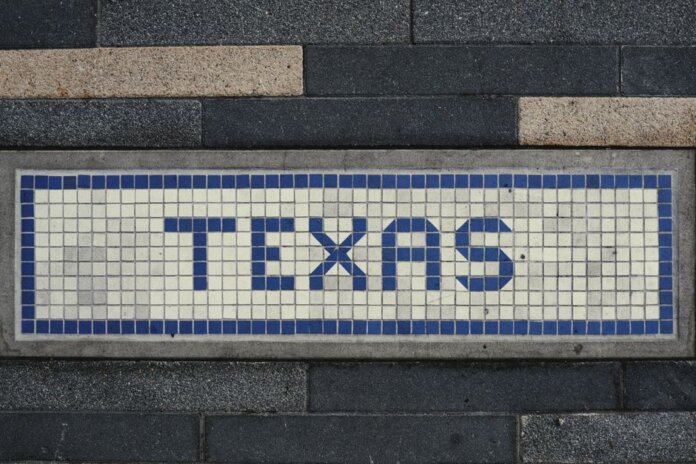Unique mosaic tile artwork spelling 'Texas' on a sidewalk in Houston, TX.