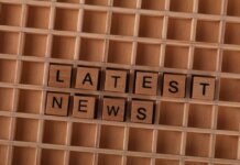 Wooden letter blocks spelling Latest News on a grid background, ideal for media themes.