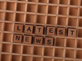 Wooden letter blocks spelling Latest News on a grid background, ideal for media themes.