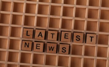 Канада следит за ситуацией после наводнений в Непале и Китае Wooden letter blocks spelling Latest News on a grid background, ideal for media themes.