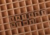 Wooden letter blocks spelling 'Latest News' on a grid surface. Ideal for media concepts.