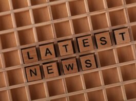 Wooden letter blocks spelling 'Latest News' on a grid surface. Ideal for media concepts.