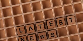 Wooden letter blocks spelling 'Latest News' on a grid surface. Ideal for media concepts.