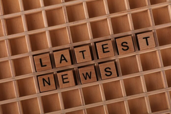 Wooden letter blocks spelling 'Latest News' on a grid surface. Ideal for media concepts.