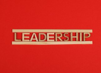 Wooden letters spelling leadership on a vibrant red background, conveying bold concepts.