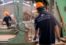 Канада и Манитоба помогут пострадавшим от тарифов работникам Workers wearing protective gear operating machinery in a factory environment, focusing on safety and production.