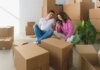 Канада улучшает мобильную связь для безопасности жителей Квебека Young couple sitting among cardboard boxes, looking at smartphone, symbolizing moving or relocation.