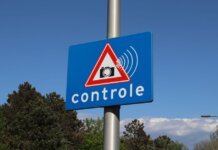 A blue road sign with a camera icon and 'controle' text indicates speed monitoring.