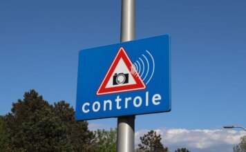 A blue road sign with a camera icon and 'controle' text indicates speed monitoring.