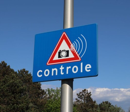 A blue road sign with a camera icon and 'controle' text indicates speed monitoring.