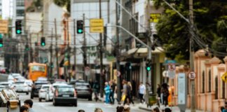 A bustling urban crosswalk with pedestrians and traffic during the day.
