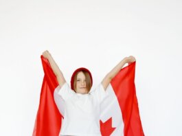 A child joyfully holding a Canadian flag, celebrating patriotism and freedom.